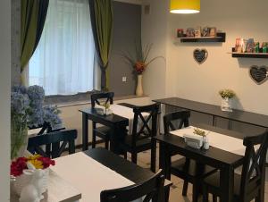 uma sala de jantar com mesas e cadeiras e uma janela em Sunny Hotel em Lviv