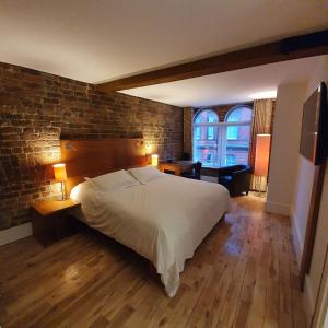 1 dormitorio con 1 cama grande y pared de ladrillo en Hope Street Hotel, en Liverpool