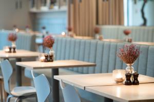 a row of tables with vases of flowers on them at Hotel Odeon in Odense