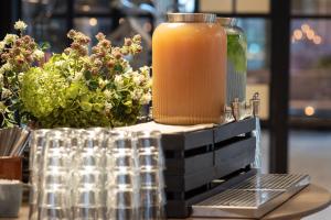 a jar of orange juice sitting on a table with flowers at Hotel Odeon in Odense