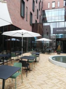 a patio with tables and chairs and umbrellas at Hotel Odeon in Odense