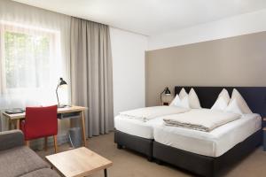 een hotelkamer met een bed, een bureau en een bank bij Gasthof Maxlhaid in Wels