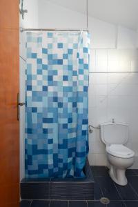 baño con aseo y cortina de ducha azul en Europe Hotel, en Argostoli