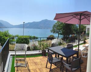 a deck with a table and chairs and an umbrella at Beachfront Villa Nautica in Kotor