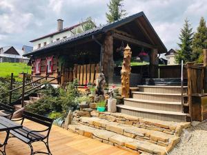 uma casa com uma escada de pedra em frente a uma casa em Zrub Niki em Ždiar