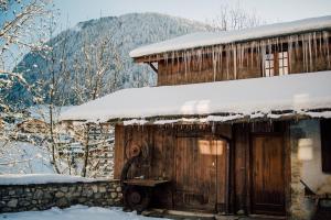 uma cabana de madeira com neve em cima em Hotel Mas de la Coutettaz, The Farmhouse em Morzine