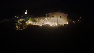 ein weißes Haus in der Nacht mit einem Leuchtturm im Hintergrund in der Unterkunft Casa Margot2 in Cadaqués