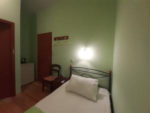 um quarto verde com uma cama com uma almofada branca em Christina Guest House em Mystras