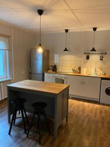 a kitchen with a table and two stools in it at Vecliepas in Vārve