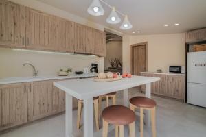 een keuken met een witte tafel en twee stoelen bij Milk and Honey Residence in Zakynthos