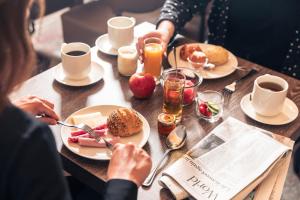 una mujer sentada en una mesa con platos de comida en Le Grand Hotel, en Estrasburgo