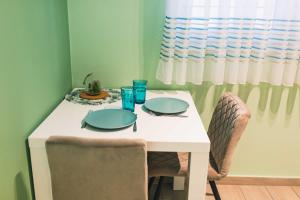 a white table with two plates and glasses on it at The Place Apartments Hebrangova in Zagreb