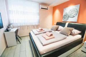 a bedroom with a bed with pink pillows on it at The Place Apartments Hebrangova in Zagreb