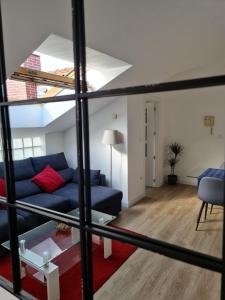 a living room with a blue couch and a table at Apartamento nuevo en El Astillero in El Astillero