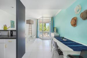 uma cozinha com uma mesa e uma parede azul em Vilarosa Oceanside by Encantos do Algarve - 1B em Portimão