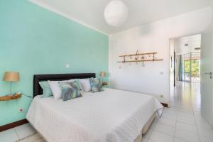 um quarto branco com uma grande cama branca com almofadas em Vilarosa Oceanside by Encantos do Algarve - 1B em Portimão