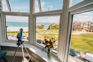 uma janela com um vaso de flores e uma câmara em OYO Minerva Guesthouse em Newquay