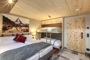 1 dormitorio con 2 camas y 1 litera en Hotel Derby, en Zermatt