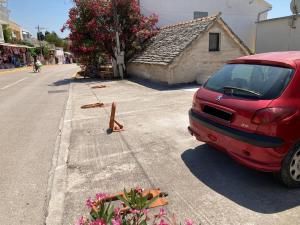 um carro vermelho estacionado ao lado de uma rua em Rooms 22 - Beachfront em Primošten