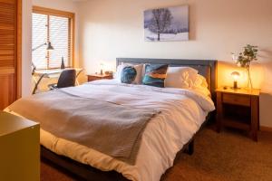 Un dormitorio con una cama grande con una persona sobre ella en SKI IN, WALK OUT! The perfect mountain retreat!, en Crested Butte