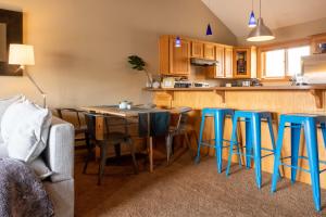 cocina con mesa y taburetes azules en SKI IN, WALK OUT! The perfect mountain retreat!, en Crested Butte