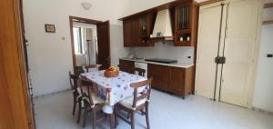 una cucina con tavolo e sedie e una cucina con tavolo e tavolo di La casa nel barocco a Lecce