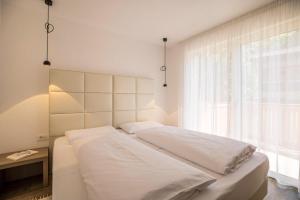 een wit bed in een kamer met een raam bij Apartment Cinch Residence Bun Ste in San Vigilio Di Marebbe