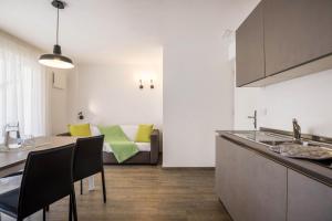 een keuken en een woonkamer met een bank bij Apartment Cinch Residence Bun Ste in San Vigilio Di Marebbe