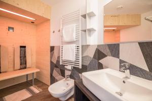 een badkamer met een wastafel, een toilet en een spiegel bij Apartment Cinch Residence Bun Ste in San Vigilio Di Marebbe