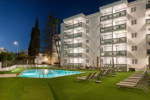 um edifício de apartamentos com piscina à noite em Roca Verde - Playa del Inglés em Playa del Inglés