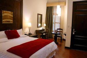 a hotel room with a large bed and a desk at Camino Real Antigua in Antigua Guatemala