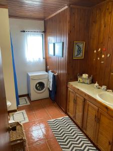 y baño con lavabo y lavadora. en Casa da Costa, en Madalena