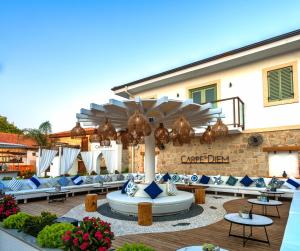 un patio avec des chaises bleues et blanches et un bâtiment dans l'établissement Carpe Diem Boutique Hotel - Adults Only, à Sidé