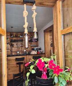 une salle à manger avec une table et quelques fleurs dans l'établissement CASA GRINDA, à Sibiu