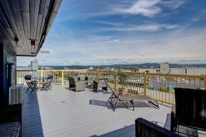 eine Terrasse mit Stühlen und Tischen auf dem Balkon in der Unterkunft North House - Hôtel Automatisé Manoir des Remparts in Québec