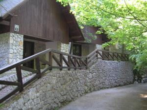 een gebouw met een stenen muur en een houten trap bij Camping Pivka Jama Postojna in Postojna