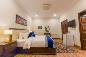 a bedroom with a bed and a dresser and a television at Khattak Lodge Murree in Murree