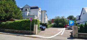 ein Parkplatz mit Straßenschild vor einem Haus in der Unterkunft Ferienwohnung in Villa in Stralsund