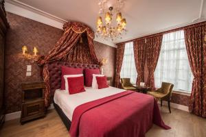 - une chambre avec un lit et un lustre dans l'établissement Boutique Hotel Huys van Leyden, à Leyde