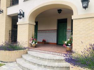 uma porta da frente de uma casa com uma porta verde em Apartmánový dom Andalusia em Veľký Meder