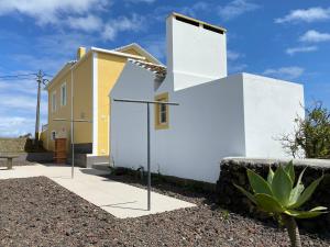 une maison aux murs blancs et jaune dans l'établissement CASA do CAMINHO, à Praia da Vitória