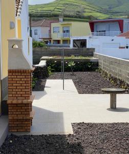 une terrasse avec un banc devant une maison dans l'établissement CASA do CAMINHO, à Praia da Vitória