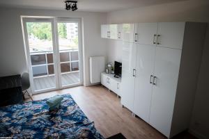 a room with a bed and white cabinets and a window at Wyszyńskiego 10 in Białystok