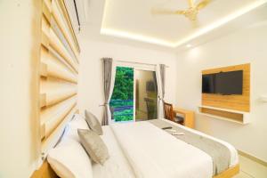 una camera con letto, TV e finestra di Oceana Hills Residency a Alleppey