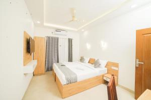 una camera con un letto e una televisione di Oceana Hills Residency a Alleppey