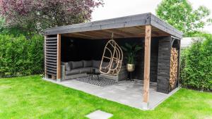 gazebo in legno con divano in cortile di Bed en Wellness Groenrust Ermelo a Ermelo