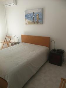 um quarto com uma cama e um quadro na parede em Casa do Algarve em Albufeira