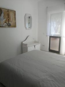 um quarto branco com uma cama e uma janela em Casa do Algarve em Albufeira