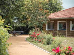 een huis met een tuin met bloemen ervoor bij Logis hôtels Le Saint Pierre in Moncoutant