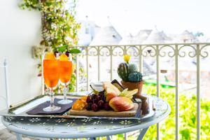 uma mesa com uma bandeja de frutas e bebidas numa varanda em Palazzo Scotto em Alberobello